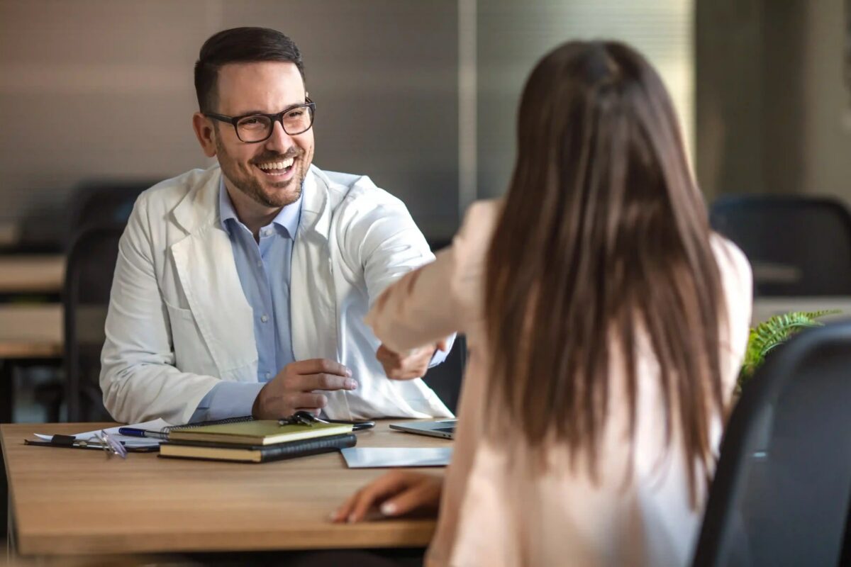 Médecin rédigeant un certificat de prolongation d'arrêt maladie sur son bureau