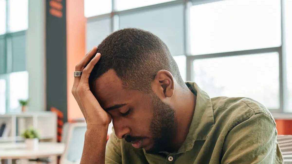 Personne autiste épuisée, la tête entre les mains, illustrant le burnout autistique