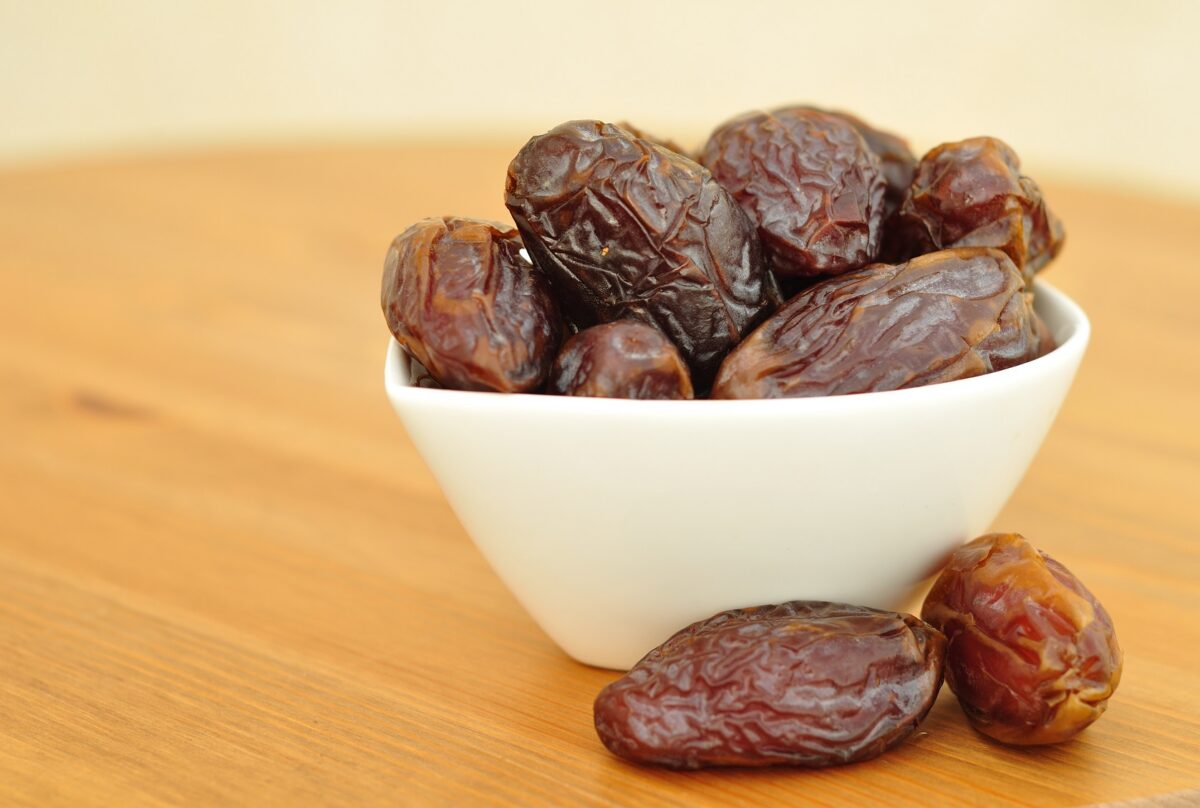 Dattes entières présentées dans un bol en bois, fruit sec naturellement sucré